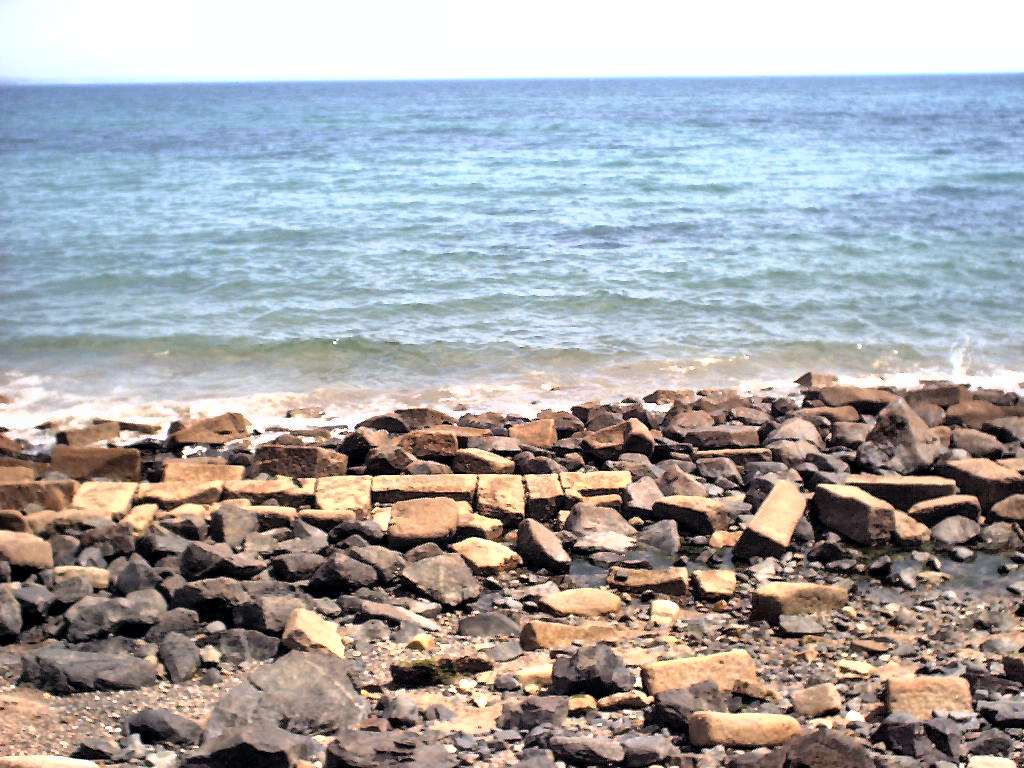 rocks and sand that are by the water