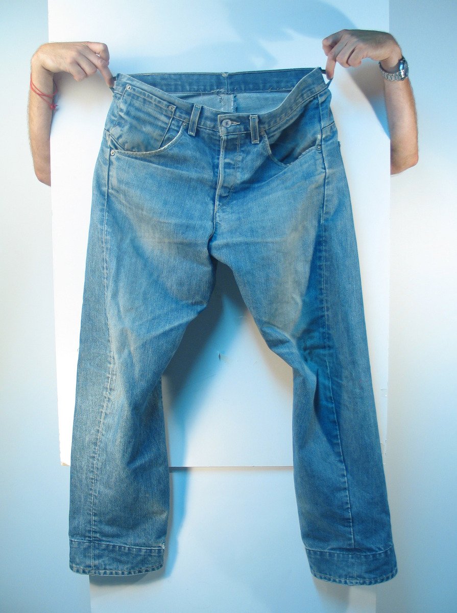 a pair of jeans held in half by someone's arm