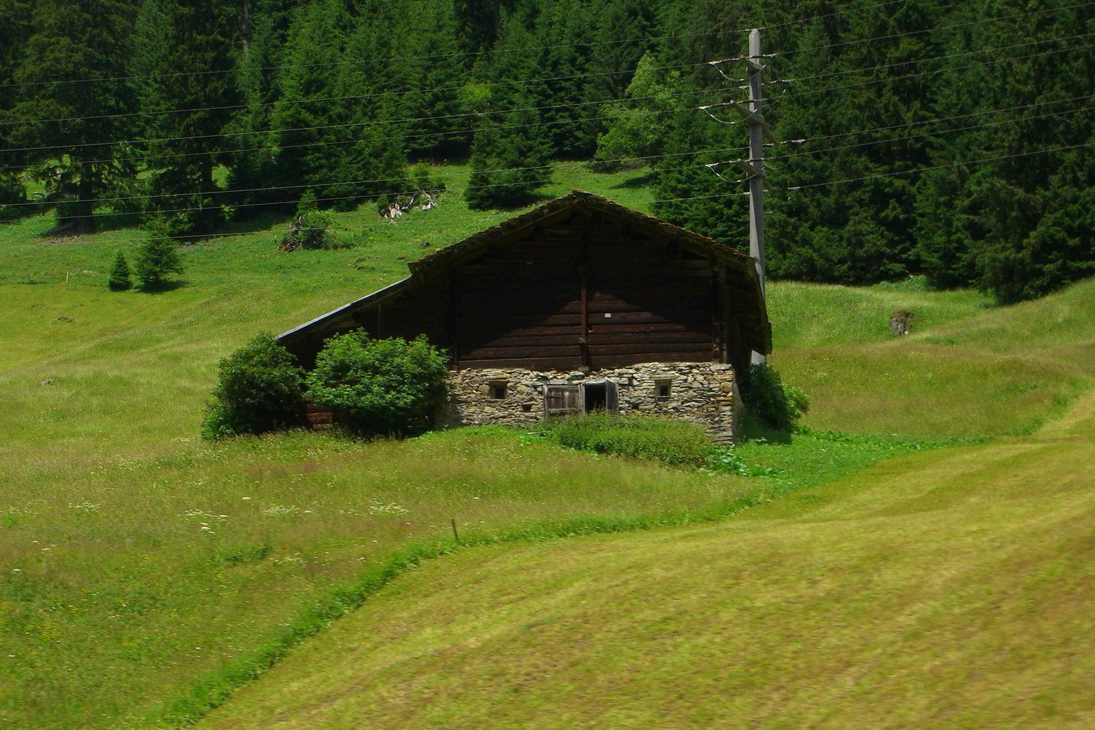 an old barn with some trees in the background