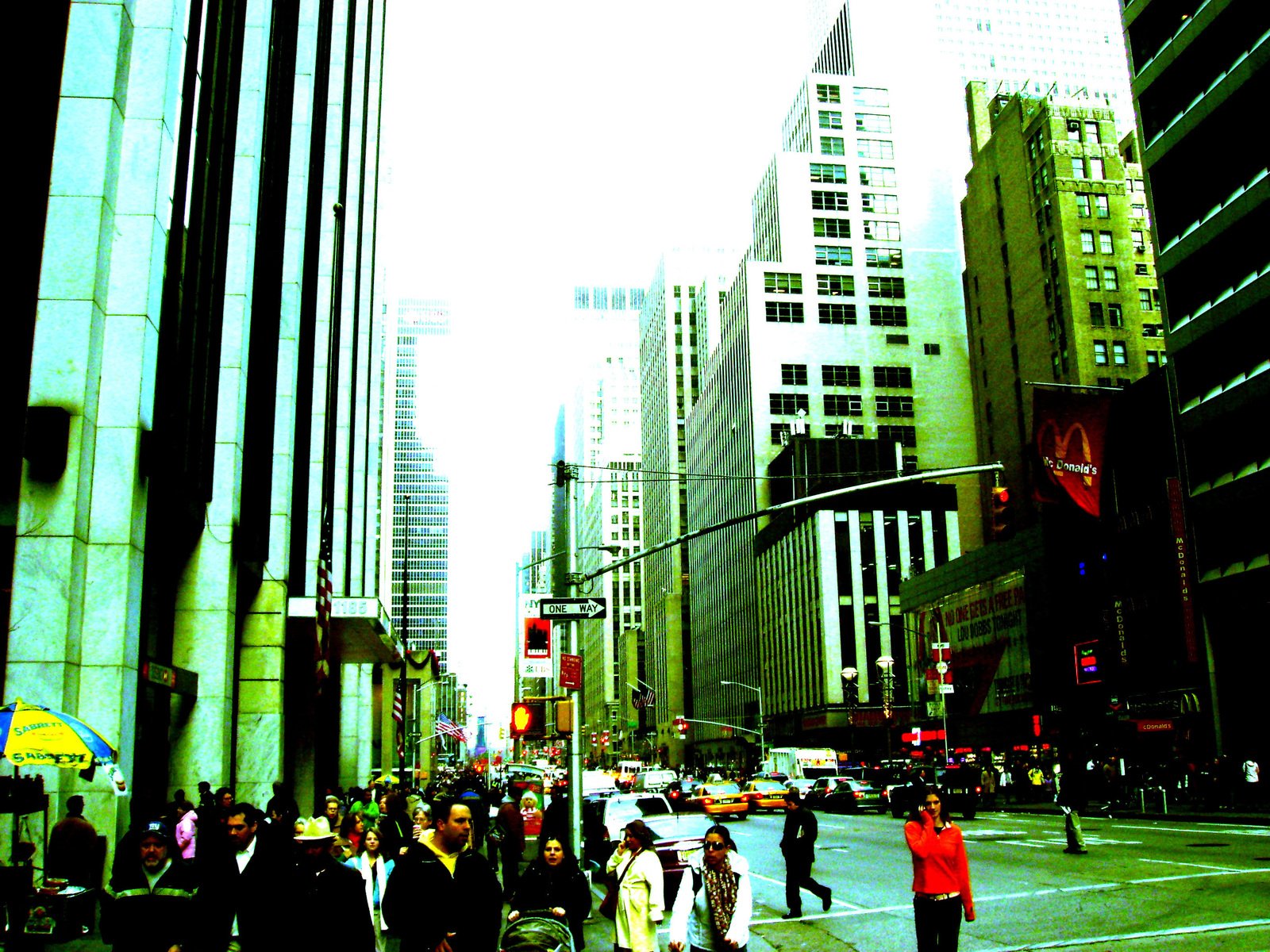 a crowd of people walking down a sidewalk in a city