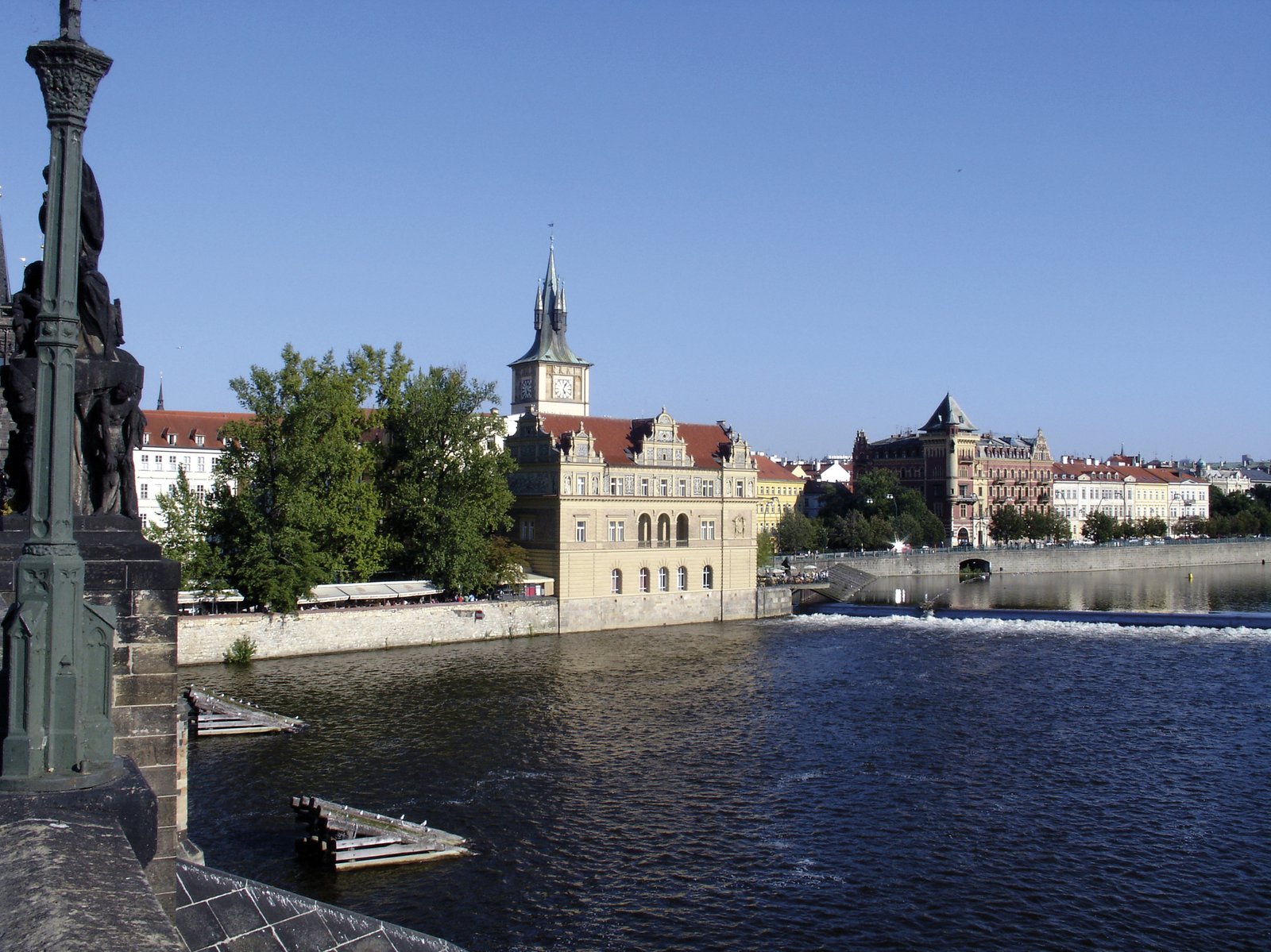 an old building overlooks the water on a sunny day