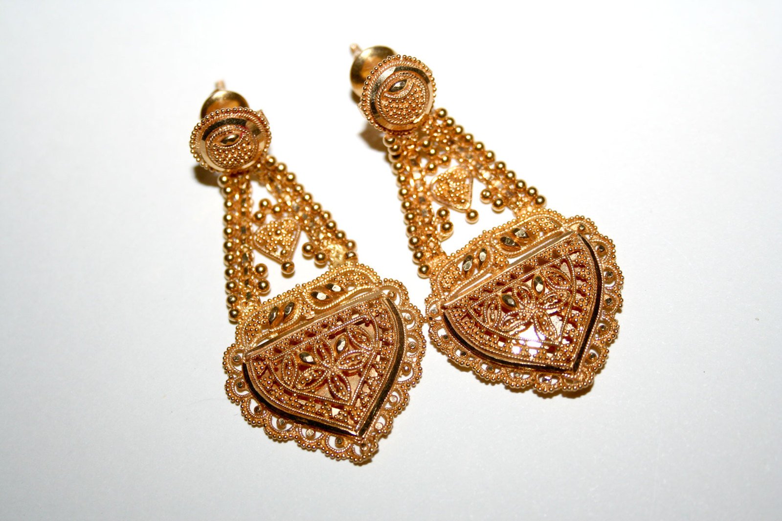 two pieces of gold colored metal ear jewelry