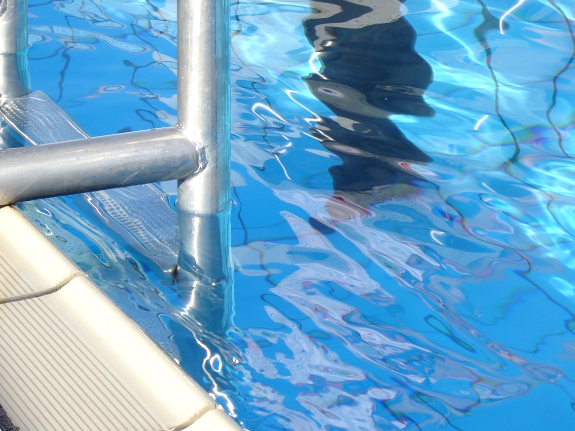 a metal railing sticking out from the side of a pool