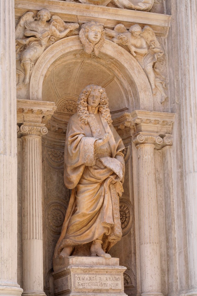 a statue of the wise man beside columns