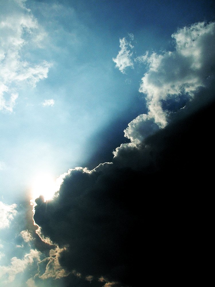 the sun rays shine down in a cloud filled sky