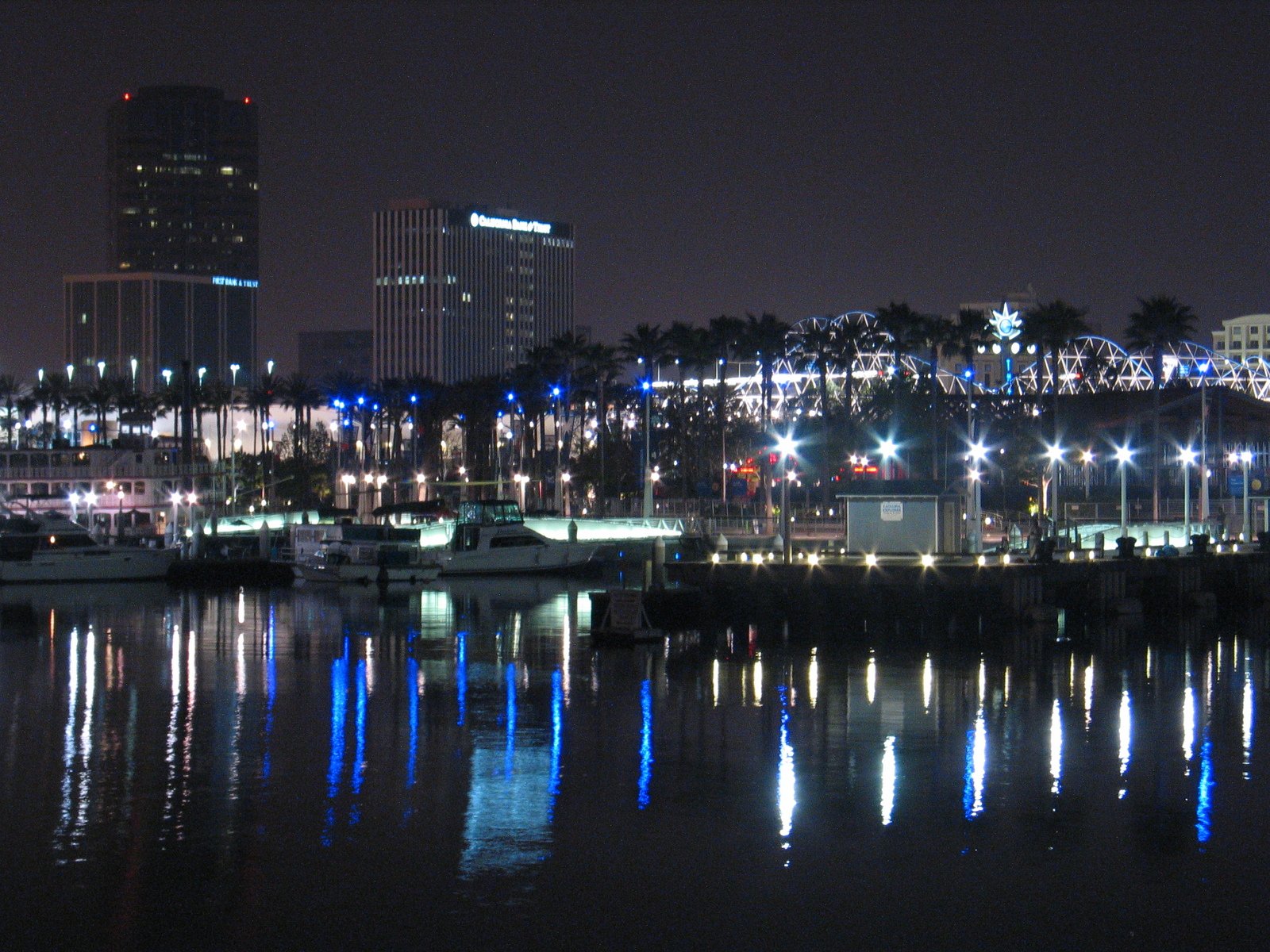 many boats are parked on the side of a large body of water