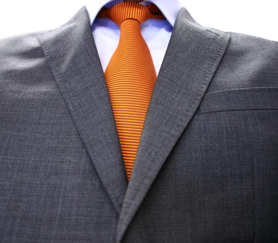 an orange and blue neck tie is attached to a suit