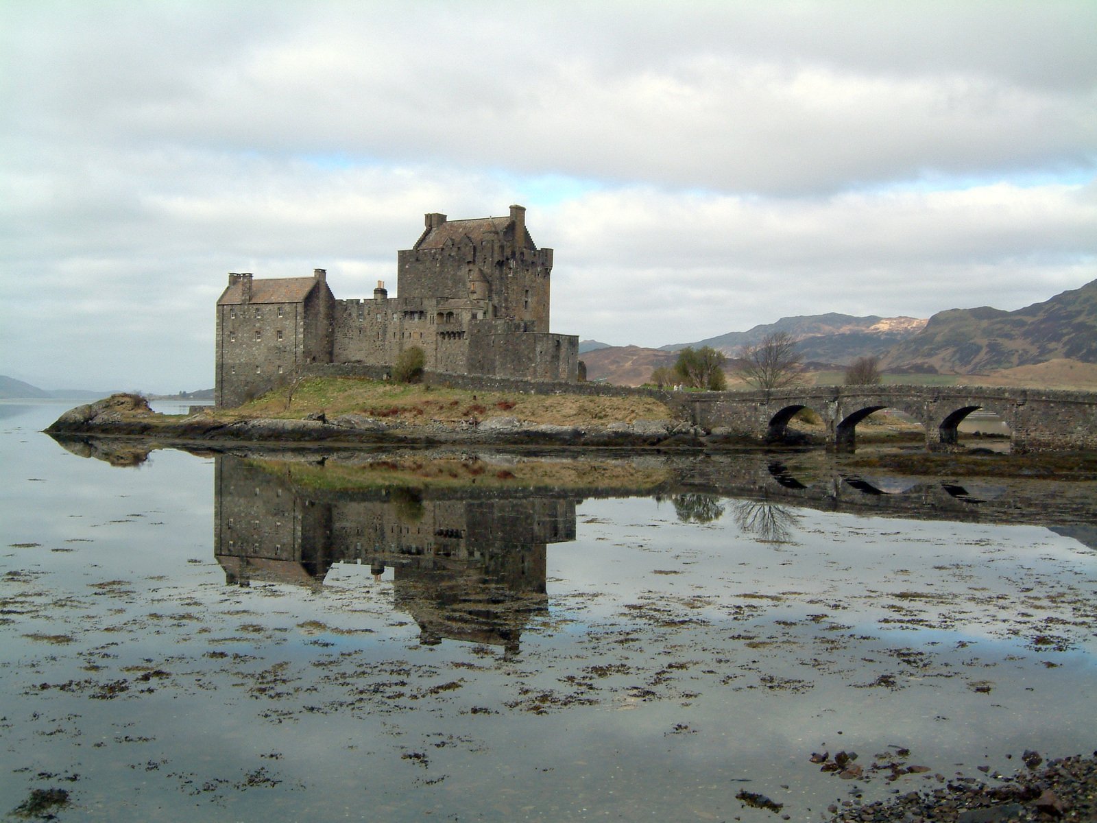 an old castle is reflected on the water