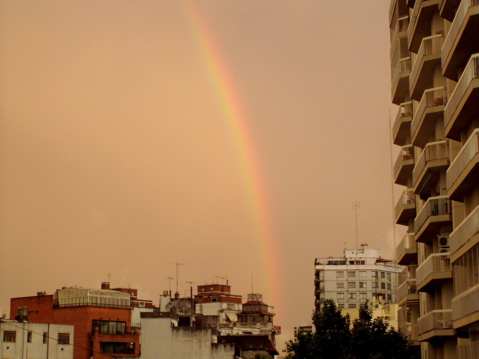 a rainbow that is standing over a city