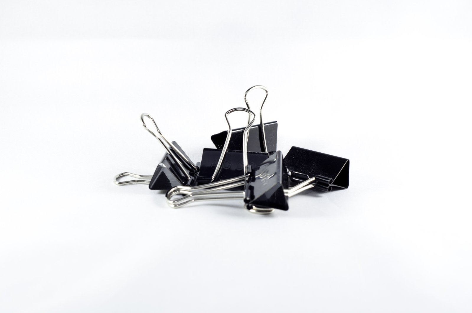 a pile of black and white paper clips on white background