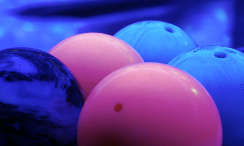 the colorful balloons are on the floor next to the bowling balls