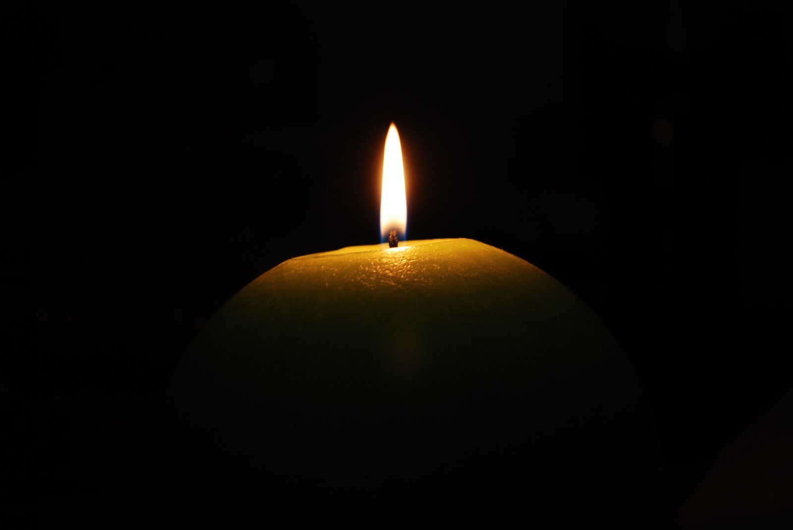 a lit candle has only been placed in a dark room
