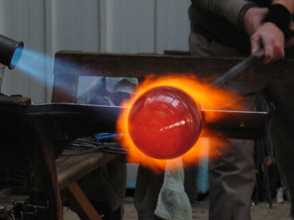 a person standing over a burning object on top of a bench
