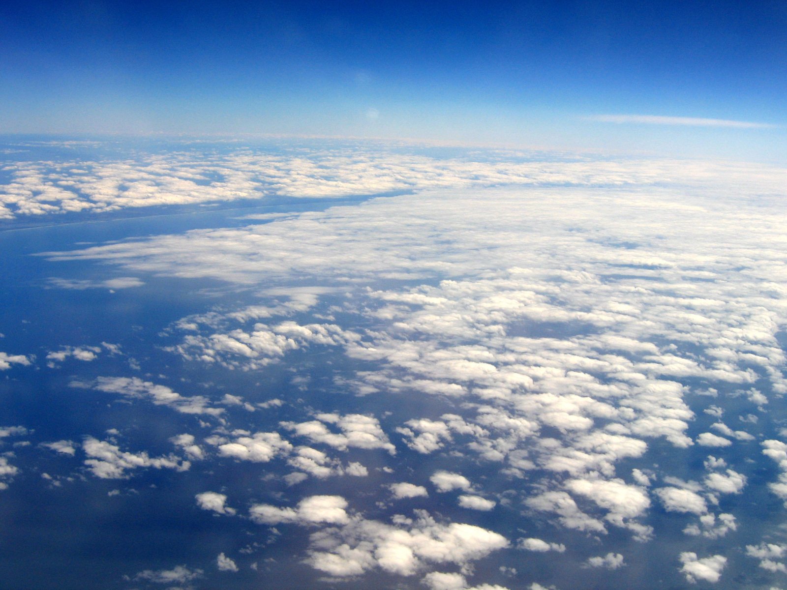 looking out an airplane window at white fluffy clouds