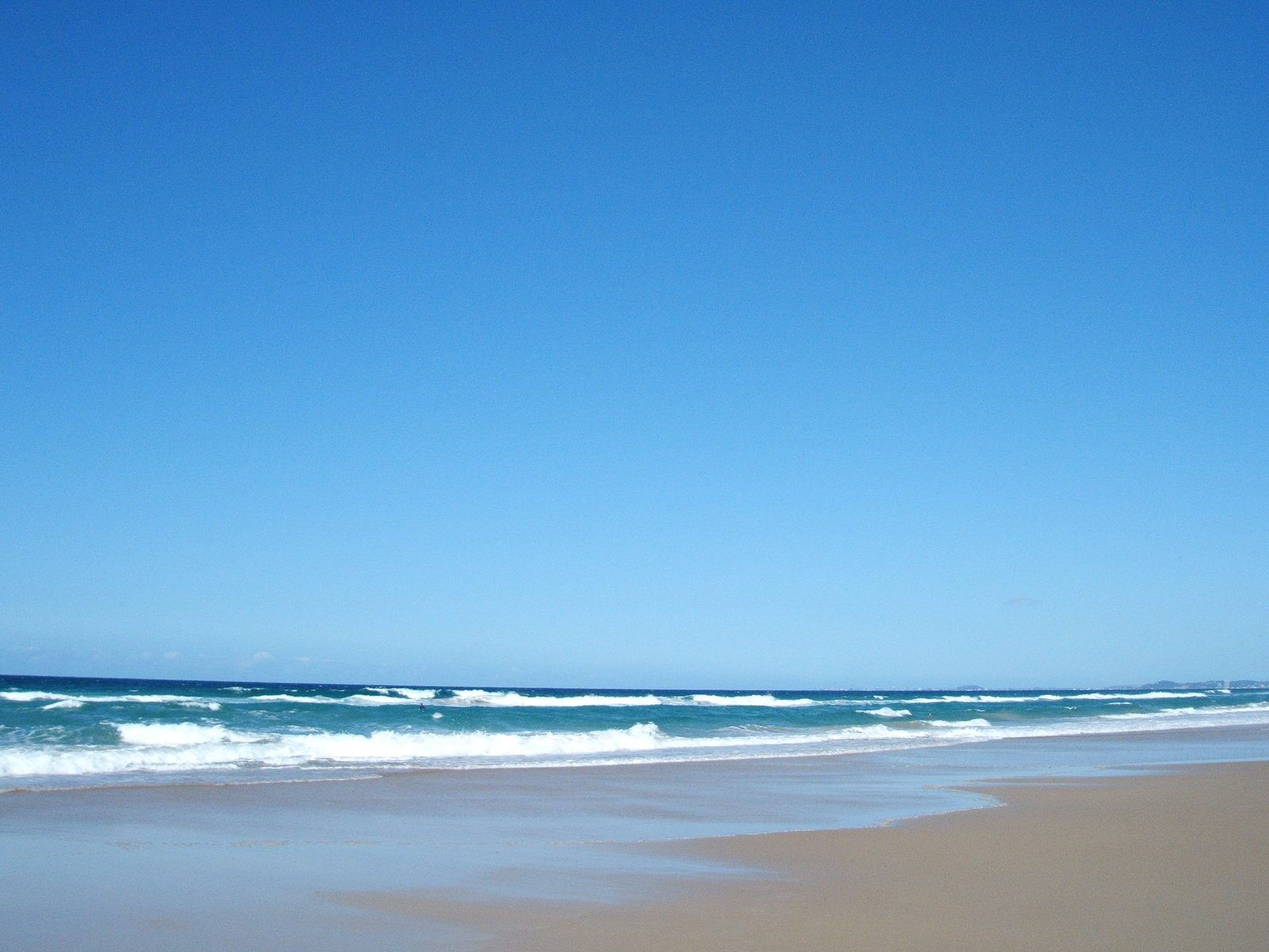 a man riding a surfboard towards the ocean