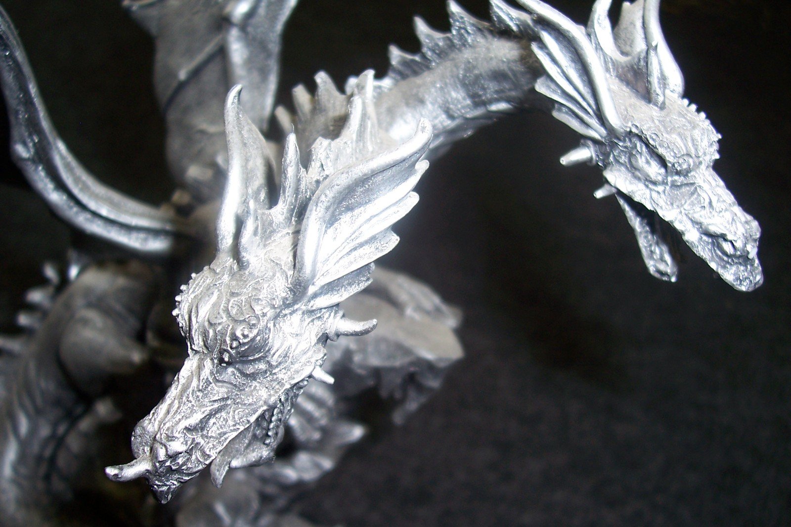 a close up of a silver statue of a dragon