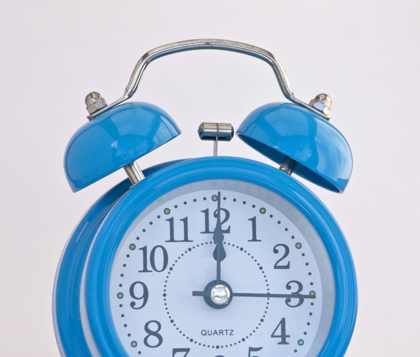 a blue clock sitting next to a white wall