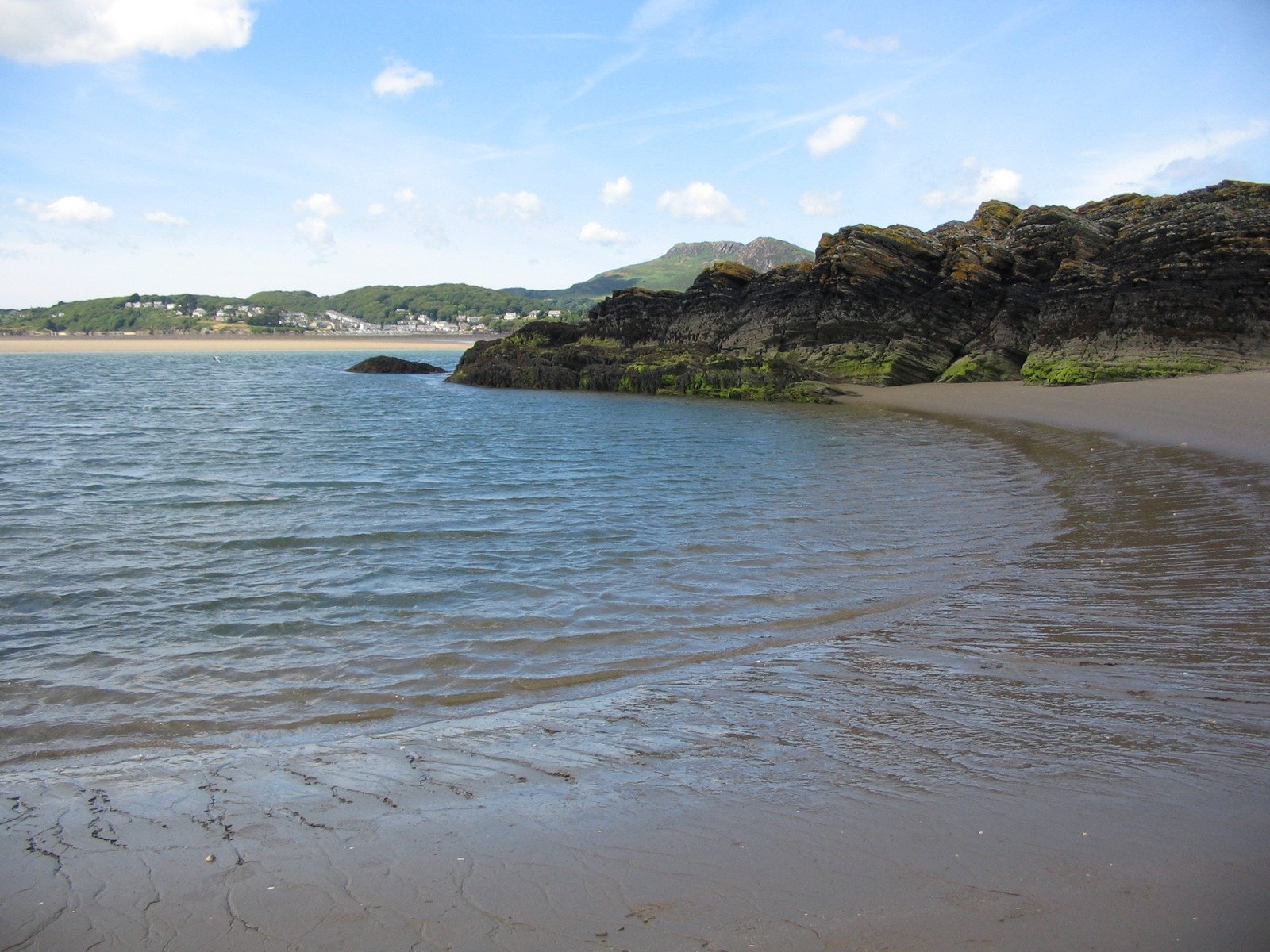 a beach next to a lake with low tide in the water