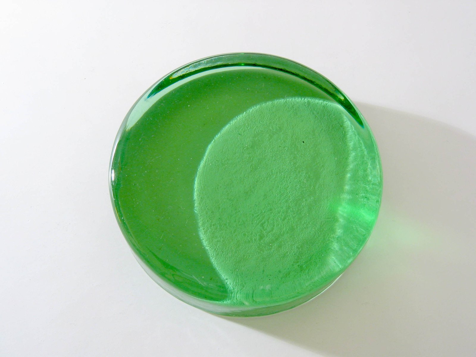 an oval glass vase filled with bright green liquid
