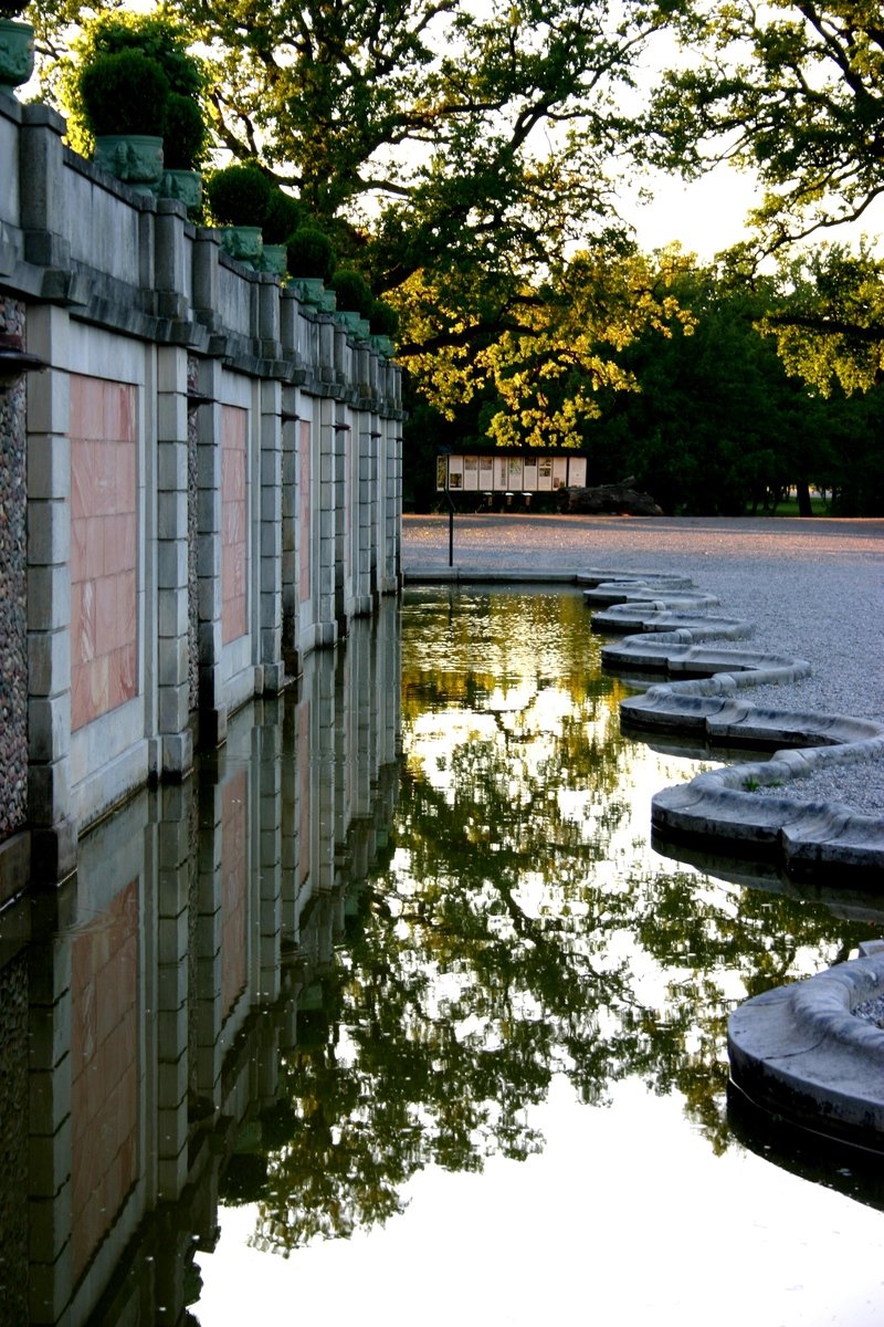 a long wall sitting next to a lake of water
