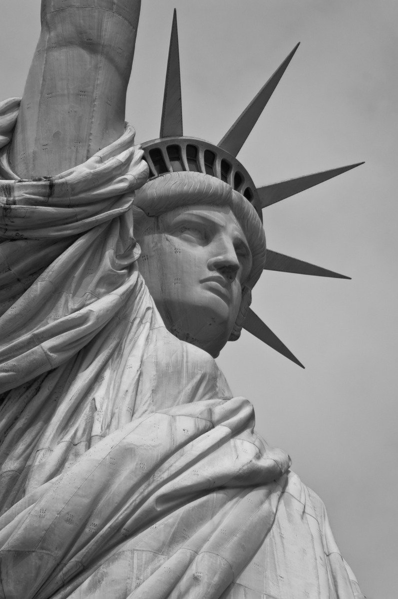 a statue of liberty stands in front of the sky