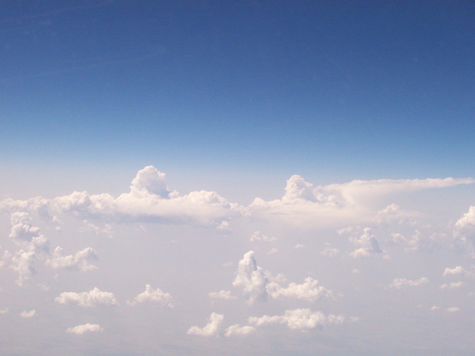 the air plane is flying above the clouds