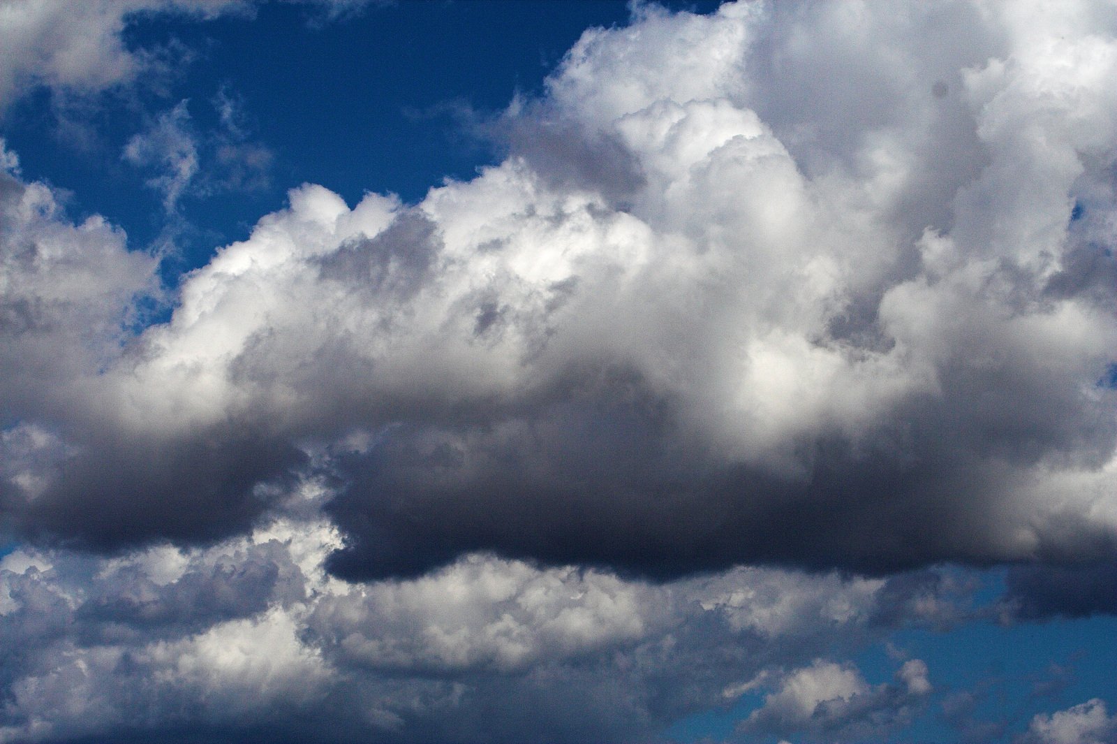 an airplane flying by clouds on a bright day