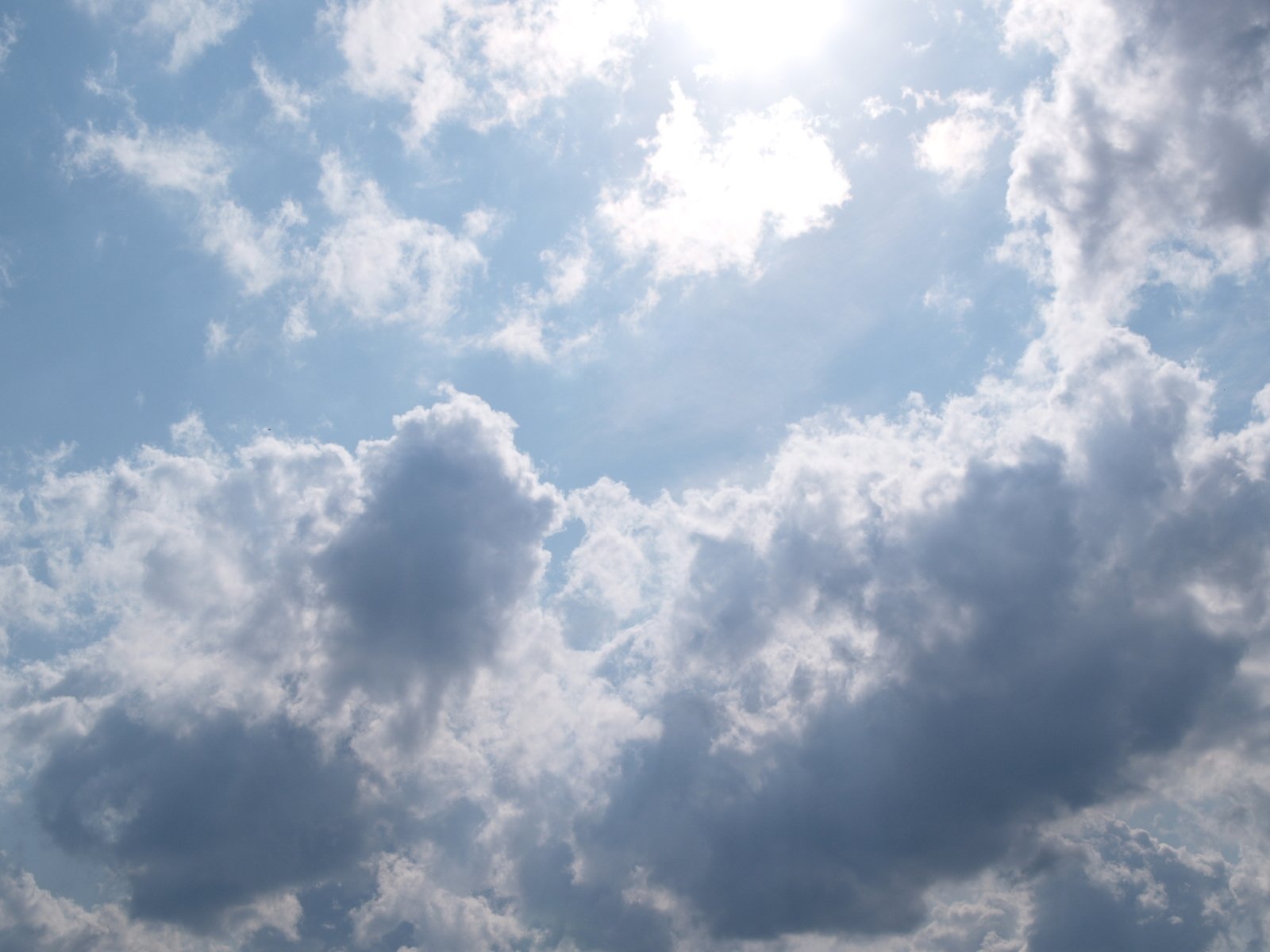 a jet plane flying in a cloudy blue sky