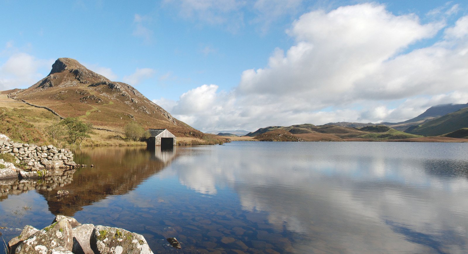 an old cabin is in the water near rocks