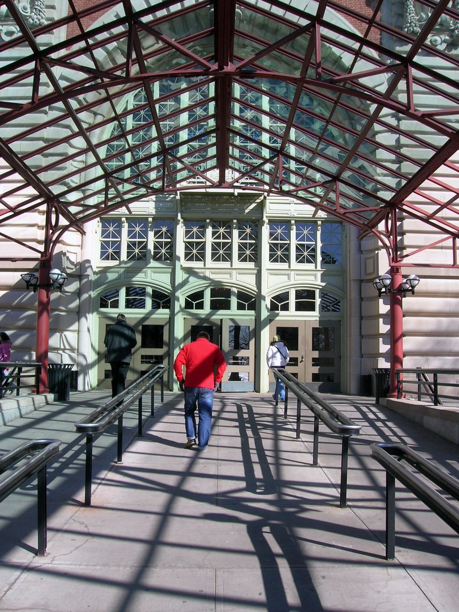 a man in red shirt walking down an arcade