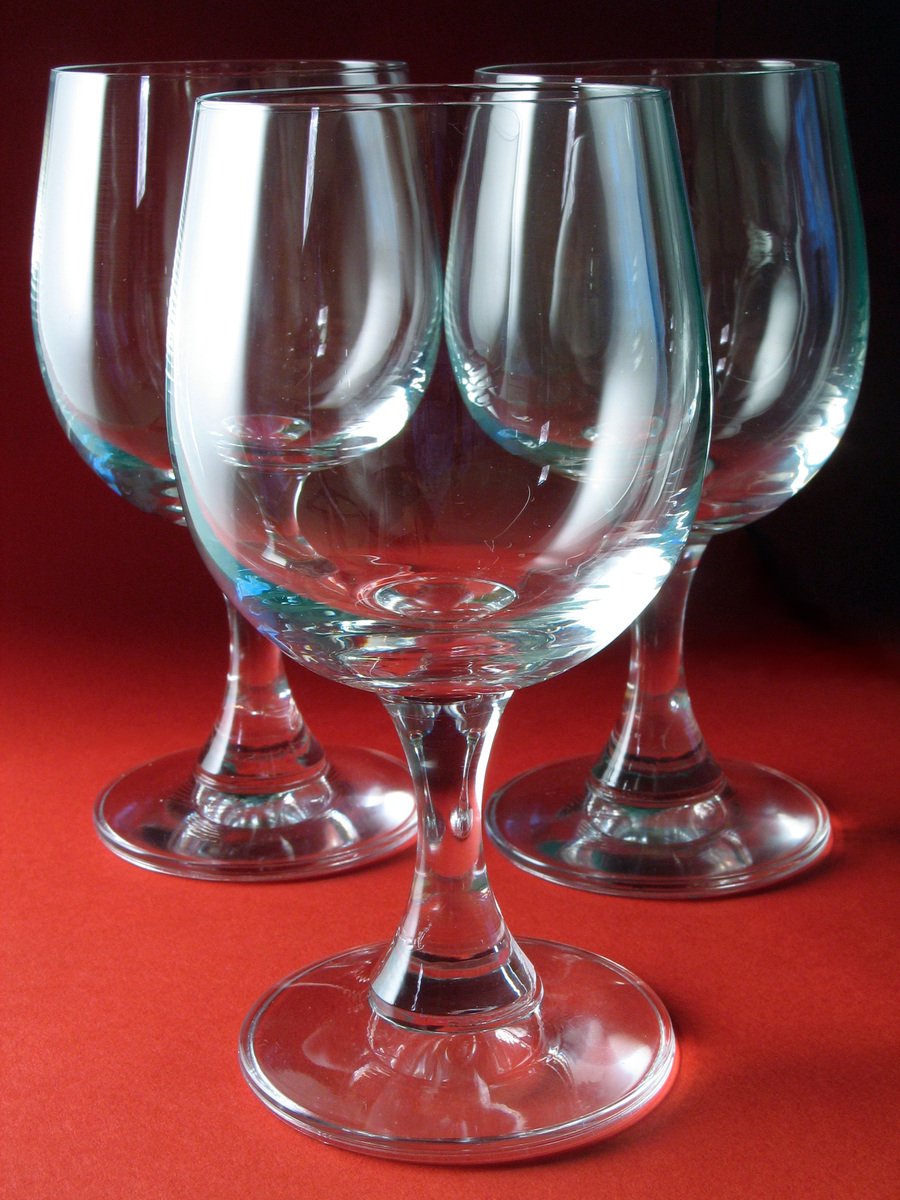three wine glasses with no base on a red background