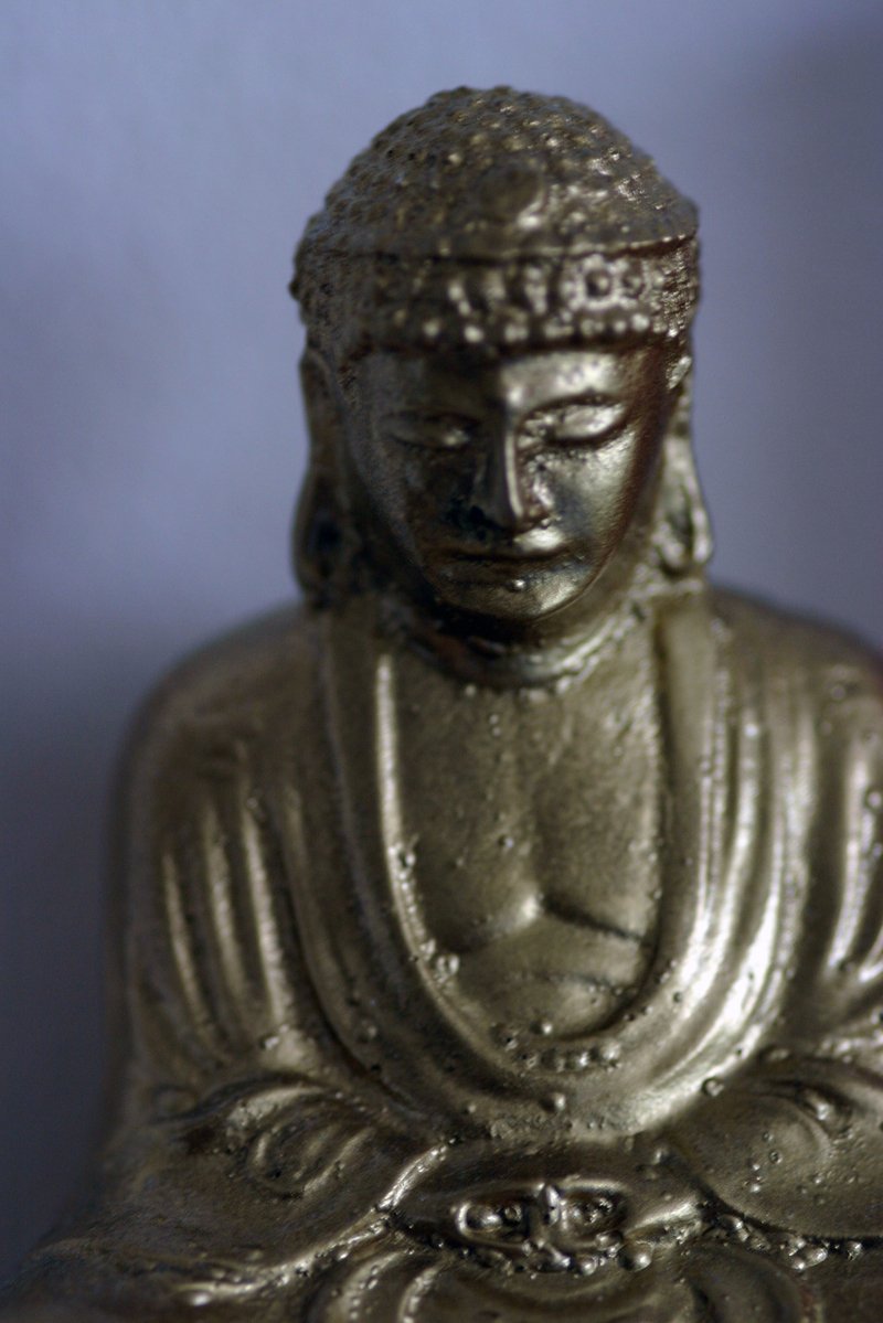 a gold statue of buddha in a white background