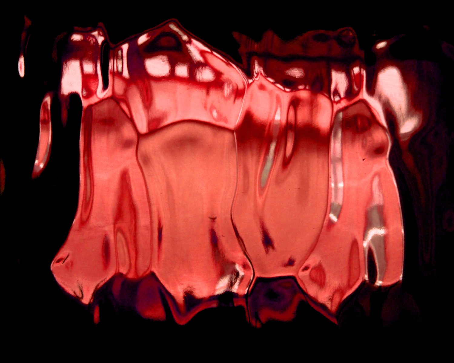 a red liquid is dripping on a black background