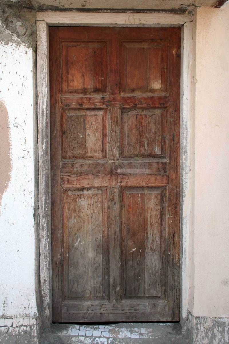 a large wood door on the side of an old house