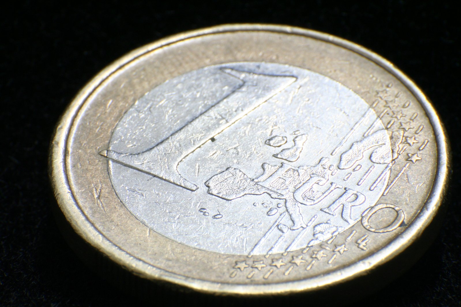 a one - euro coin is shown with a black background