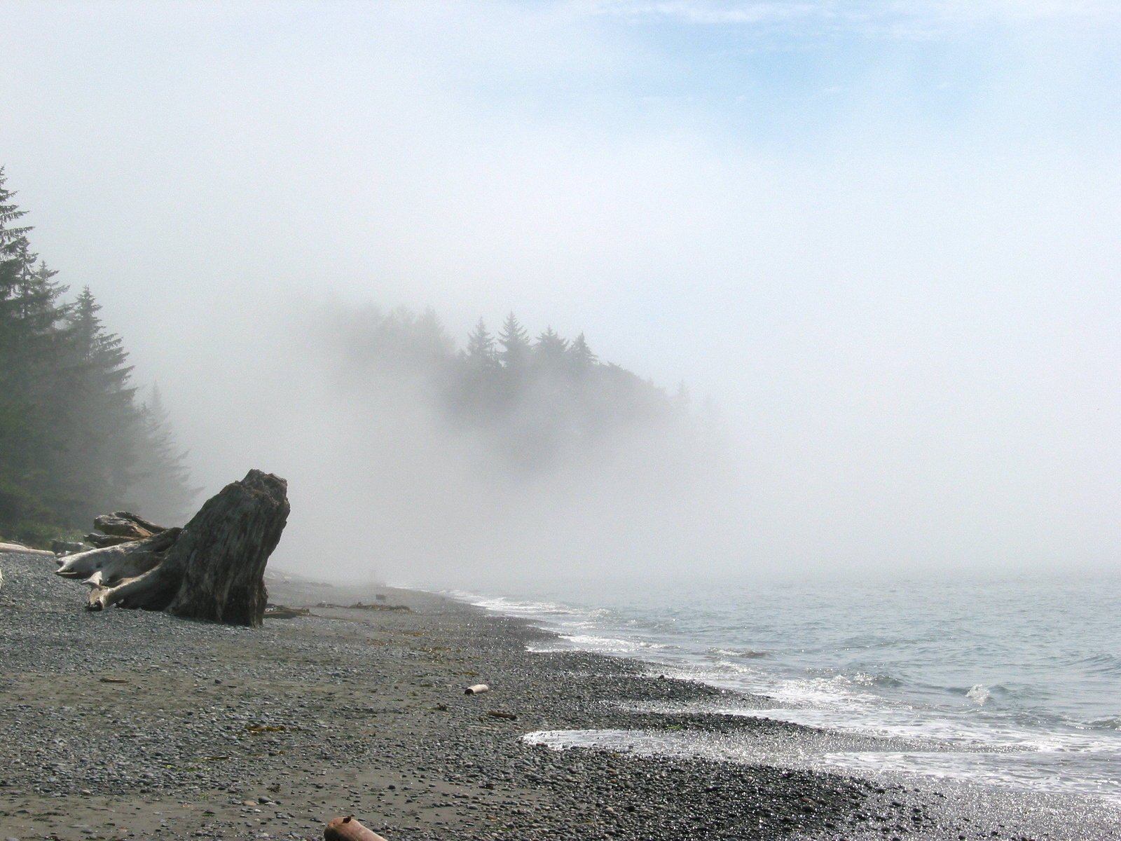 fog rising off the shore at low tide on an empty beach