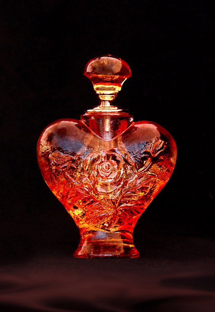 an intricately painted glass heart vase with a crystal lid