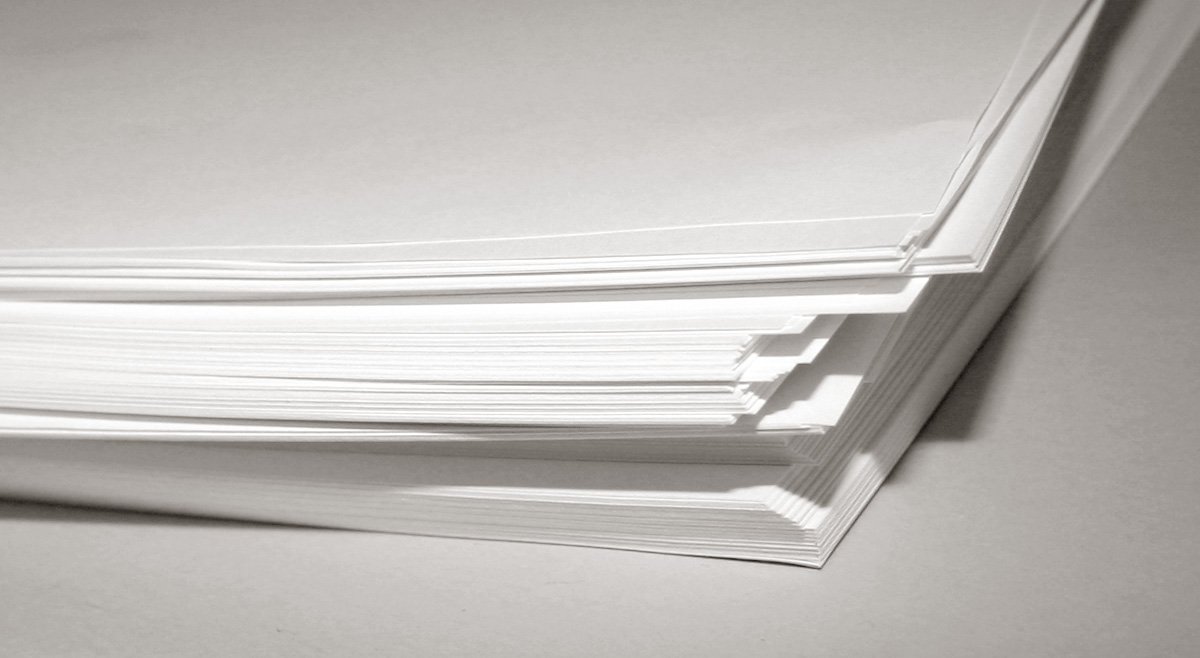 four stacks of white papers sitting on a table