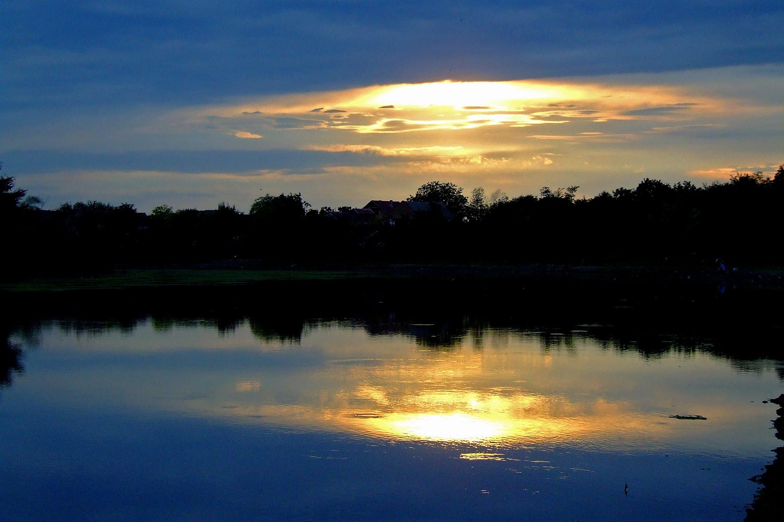 the sun is setting over a small lake