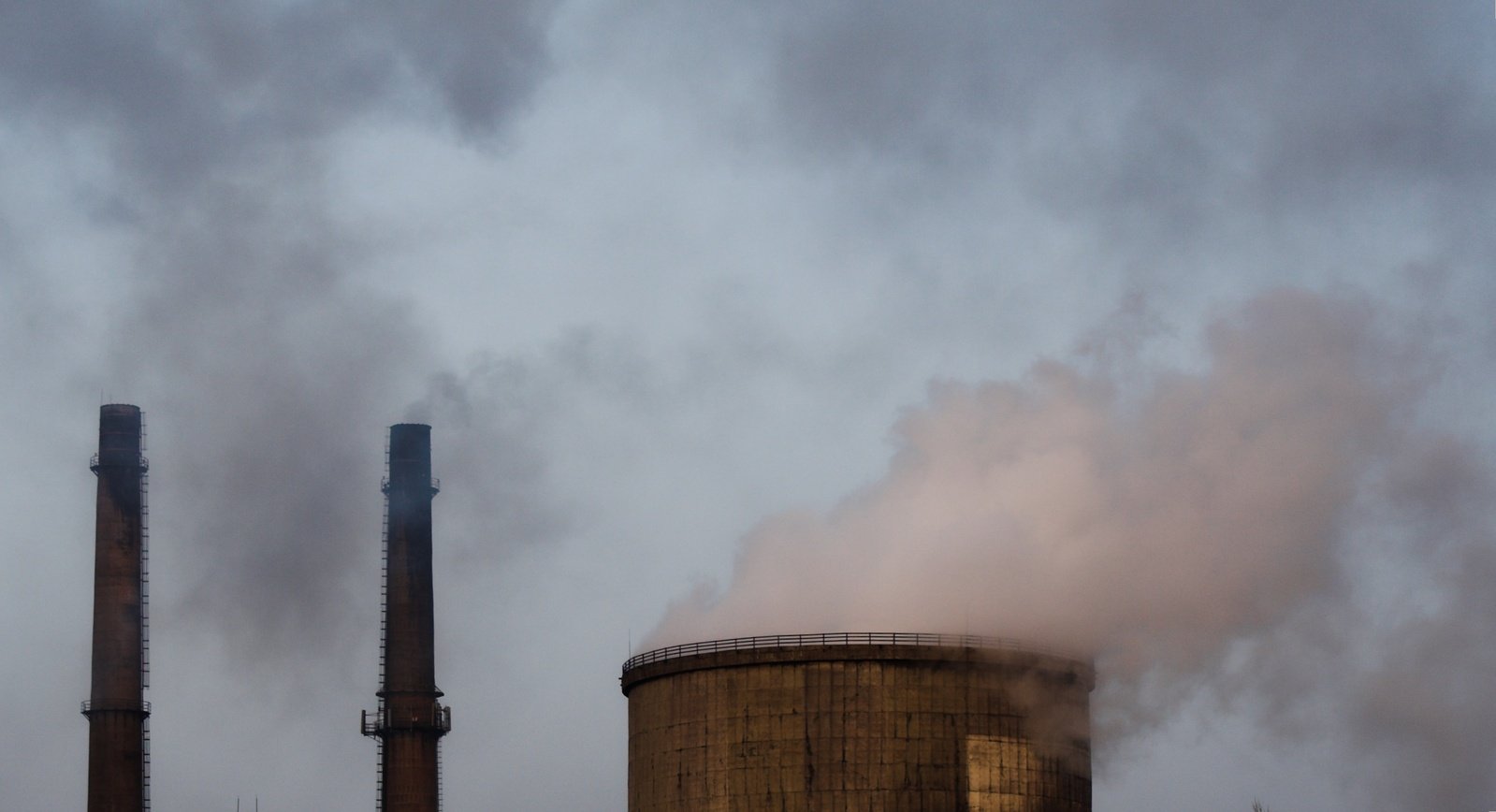 smoke billows from three large cooling towers