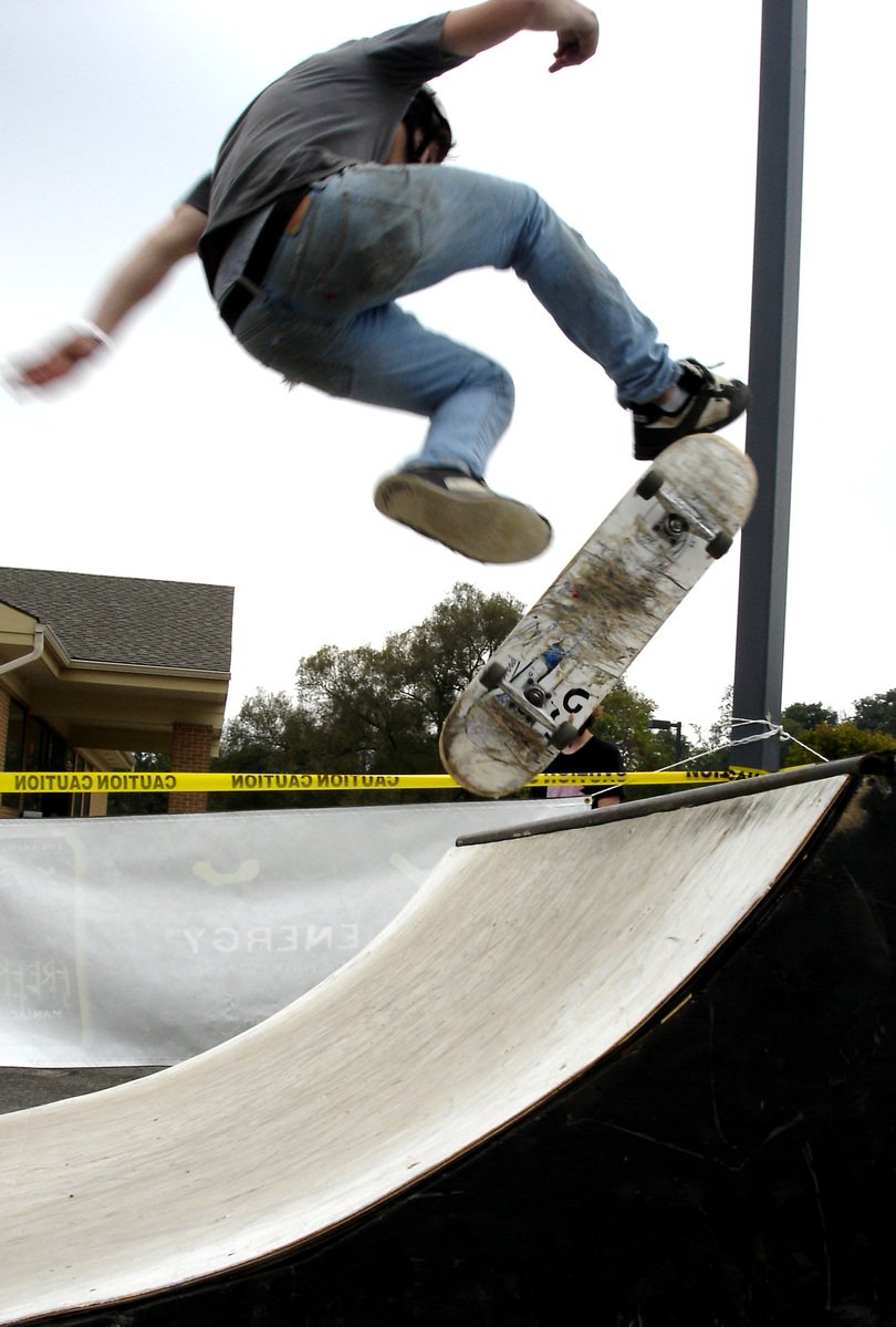 a young man flying through the air while riding a skateboard