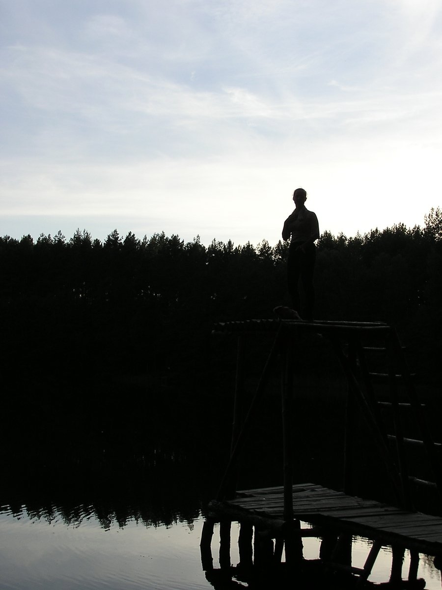 man standing on pier overlooking large body of water