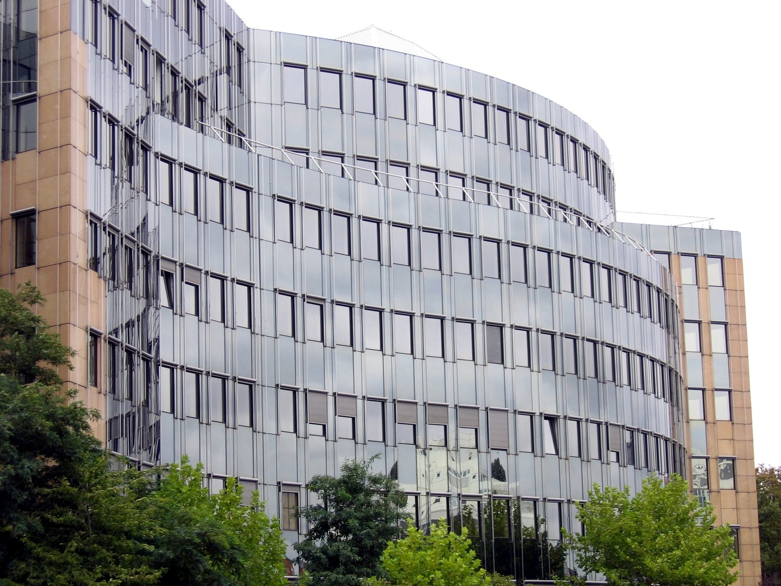 an architectural building with a circular face next to trees