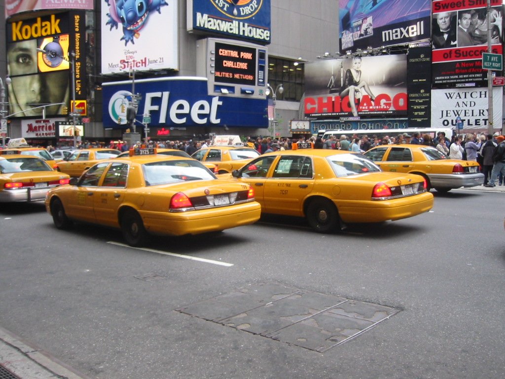 a taxi cab is sitting in front of a large building