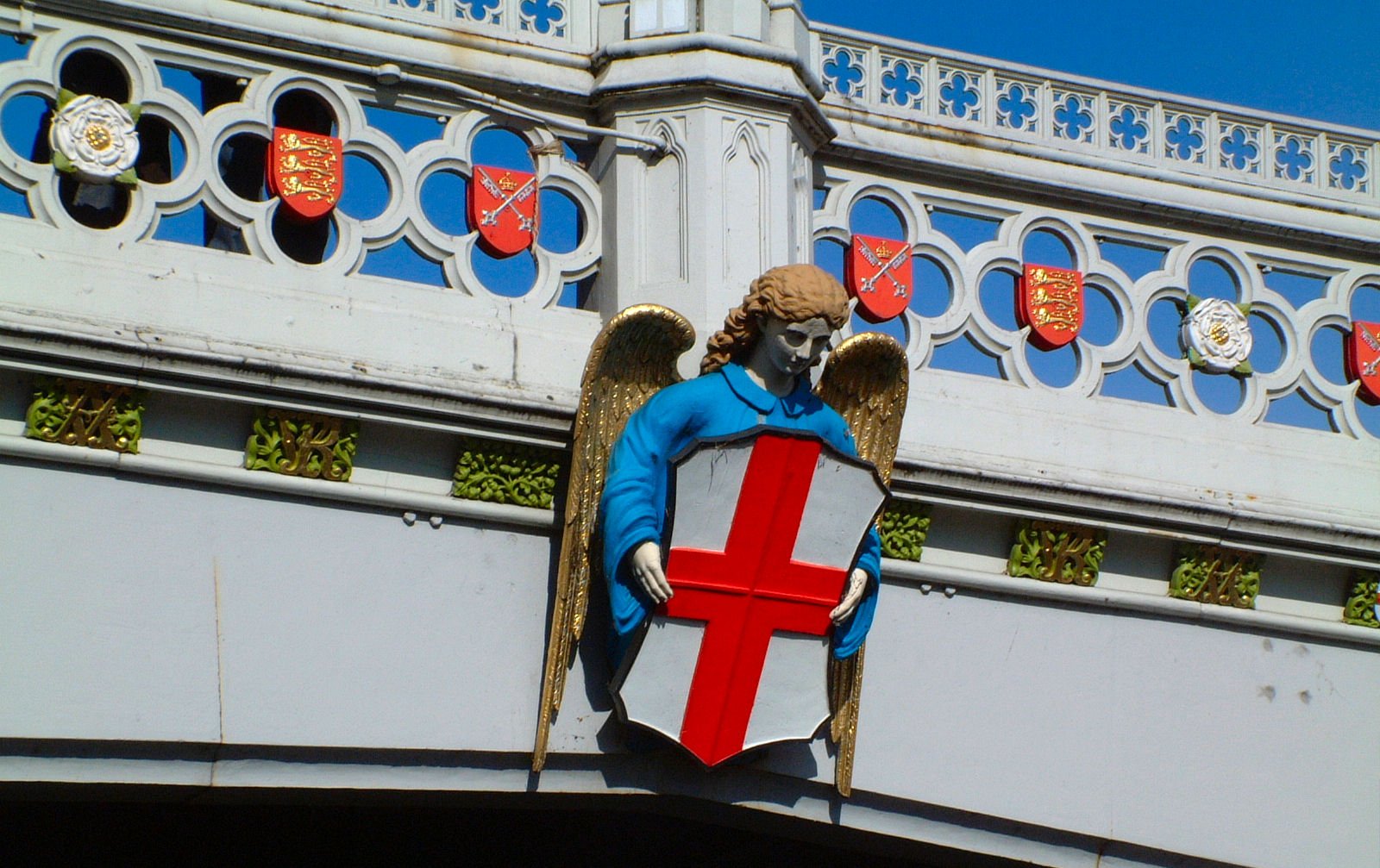 a statue that looks like an angel holding a shield