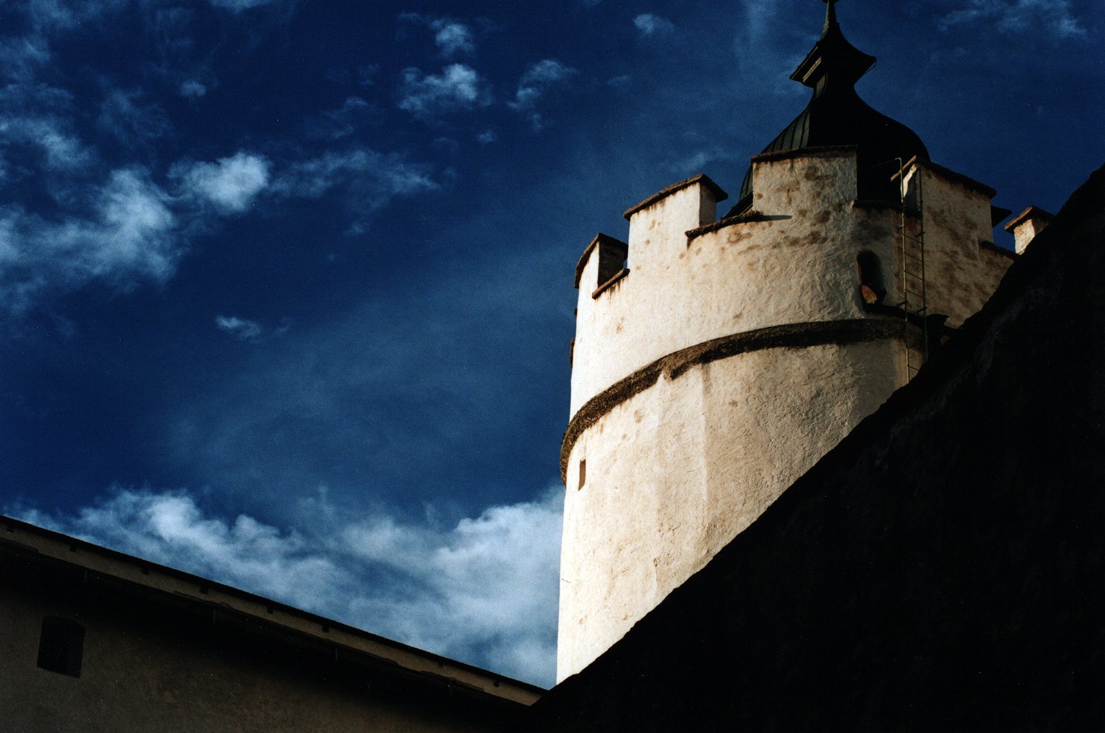 a white tower with black top against a blue sky