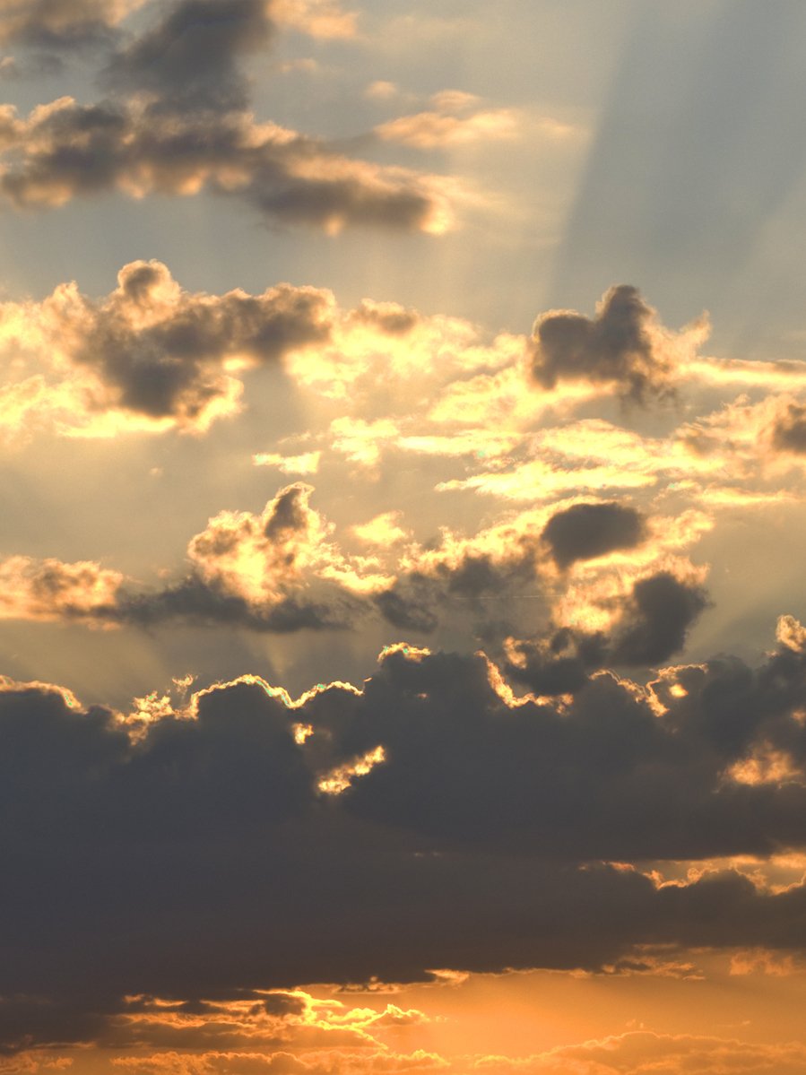 a small plane flying in front of the setting sun