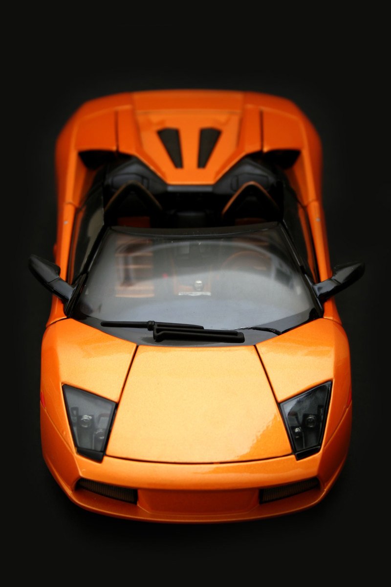 an orange sports car on a black surface