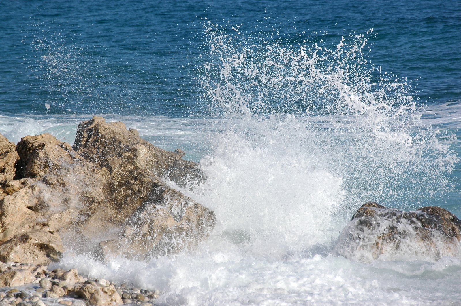 a crashing wave on rocks on the ocean