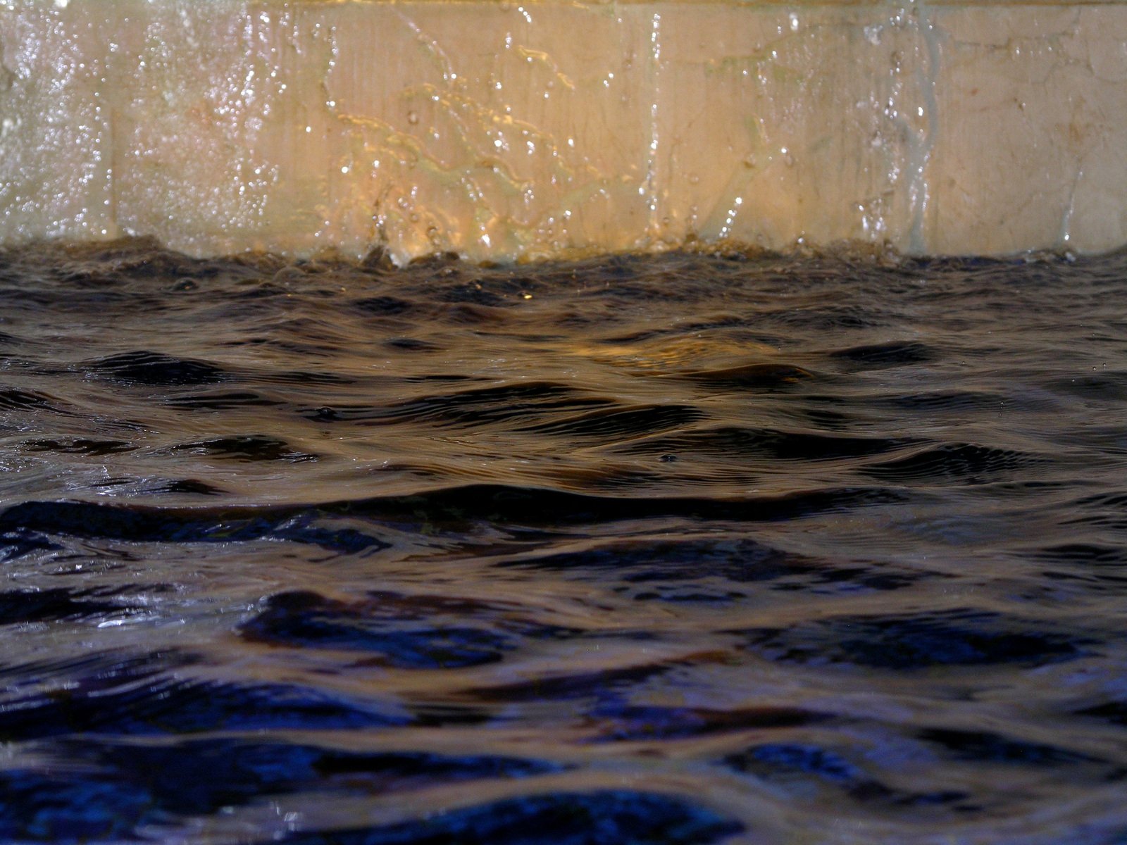 a large piece of water flowing down side of a stone wall